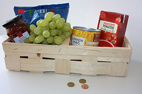 Günstig einkaufen Spankorb mit Weintrauben und haltbaren Lebensmitteln, davor ein paar Münzen